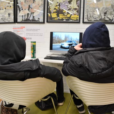 Två pojkar som tittar på en datorskärm.