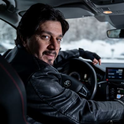 Taksikuski Barzan Namiq (oma yritys Nuuran) istumassa autossaan. Hän tekee töitä Bolt kyytisovelluksen kautta, Kannelmäki, Helsinki, 16.12.2022.