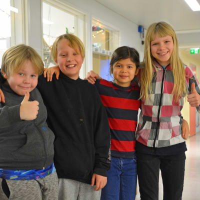 Fyra barn i en skolkorridor.