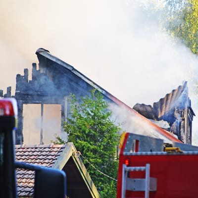 Nedbrunnet hus och brandbilar