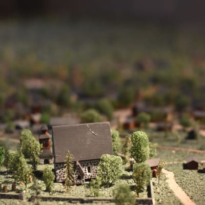 Modell i miniatyr av en gammal stad med småhus och en kyrka.