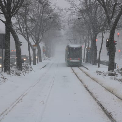 En spårvagn på vägen i snöyra.