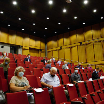 Kommunfullmäktigeledamöter i Kimitoön sitter i ett auditorium under första mötet sedan valet.