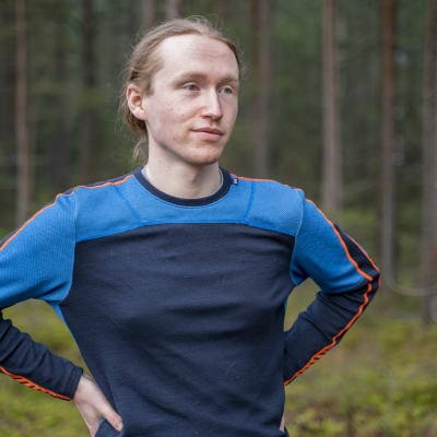 Man i löptröja i skog