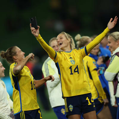 Spelare i svensk landslagströja jublar med uppsträckta händer.