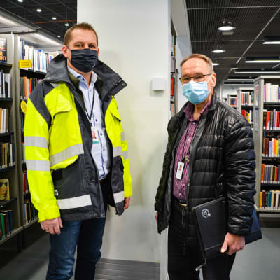 Två män på varsin sida om en sensor, i ett bibliotek.