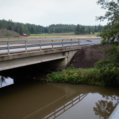 Bro för fordontrafik över en å på hösten. 