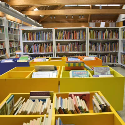Hyllor med lådor och böcker i ett bibliotek.
