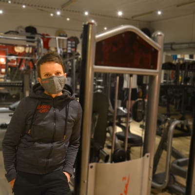 Kvinna i gym med olika träningsredskap.