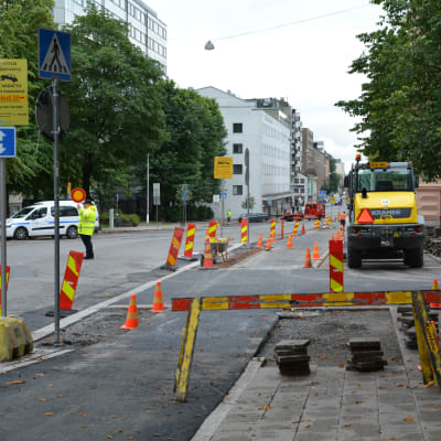 Byggarbetsplats vid Trädgårdsgatan. En person dirigerar trafiken.