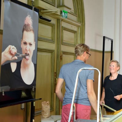 Ilar Gunilla Persson hänger upp sina fotografier i Lovisa kyrka