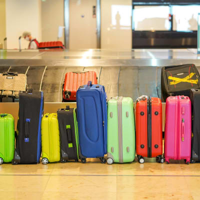 Resväskor står på en rad på ett flygplatsgolv.
