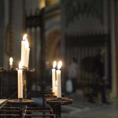 Ljus brinner i ljusstakar i Åbo domkyrka under lördagens kvällsmässa som ordnades för att hedra Åboattackens offer.