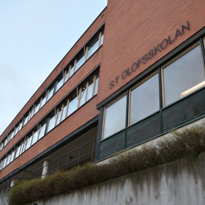 Bild på S:t Olofsskolans tegelbyggnad utifrån, skolans namn står på väggen.