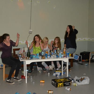 Ungdomar som spelar att de deltar i en hemmafest. 