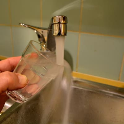 vatten som rinner från kran till dricksglas