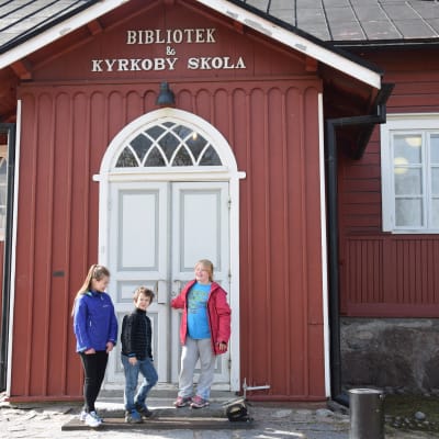 Lina Kiukkonen, Eric Bergström och Tessa Kokko utanför Kyrkoby skola i Vanda.