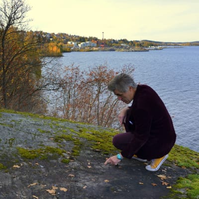 Antti Liuttunen kyykkii Onkiniemen kalliolla