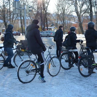 Ett gäng cyklister står vid trafikljuset i centrala Åbo.