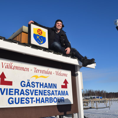 Benjamin Lundin har klättrat upp på en välkomstskylt i Ingå.
