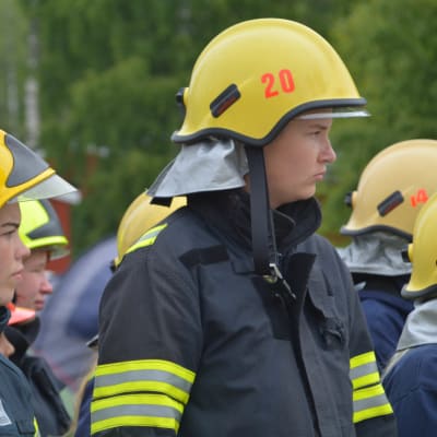 Två deltagare med gula hjälmar på brandkårslägret i Lovisa.