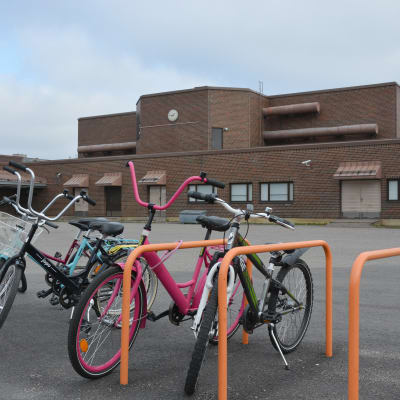 Cyklar vid ett cykelställ på en skolgård