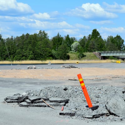 En sandgrop och en varningsstolpe i Norra hamnen i Ekenäs där hamnmagasinet stod tidigare. Hav i bakgrunden. En vacker sommardag.
