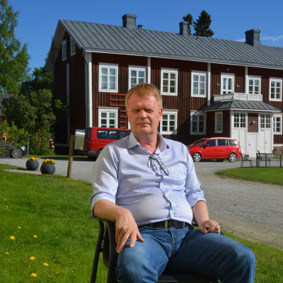 Carl-Johan Strömberg, direktör för Lagmansgården, sitter på en stol under strålande solsken.
