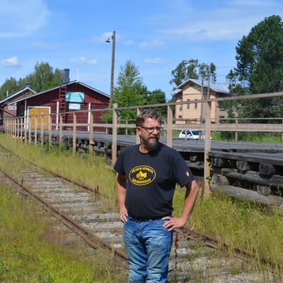 Ogräs växer mellan järnvägsspåren i Borgå, Niklas ser fundersamt på banan.