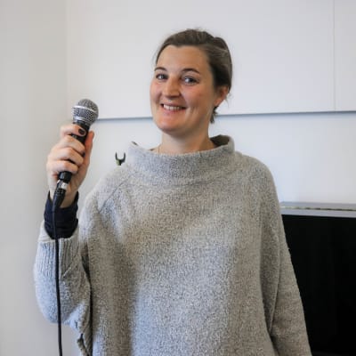 Emilia Skaag med en mikrofon i handen