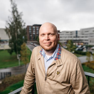 Kike Bertell står på en balkong i Västra Böle i Helsingfors 