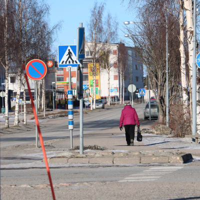 En kvinna med rosa jacka går på en gata i Närpes centrum.
