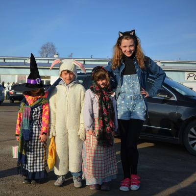 Fyra barn, två är utklädda till påskhäxor och två är utklädda till påskharar.