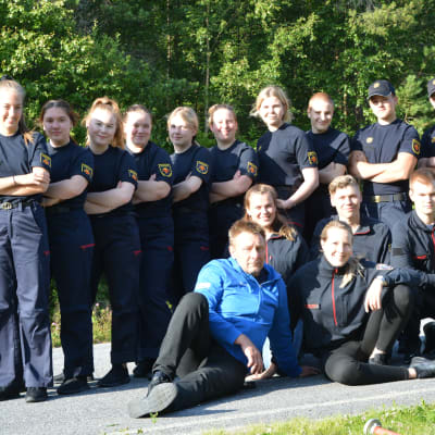 En grupp brandkårister ler mot kameran.