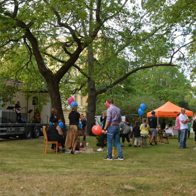 Människor med ballonger i en park.