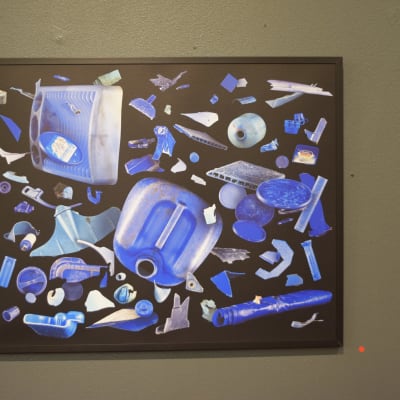 En fototavla med plastskräp i blått. Bakgrunden på tavlan är svart.