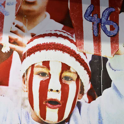 Plansch med röda och vita ränder och en barn som håller i skyltar med siffran 46.