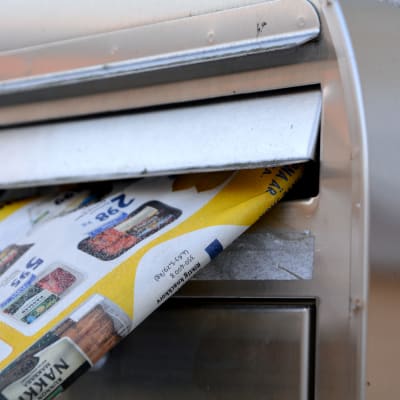 Tidning sticker ut från postlåda