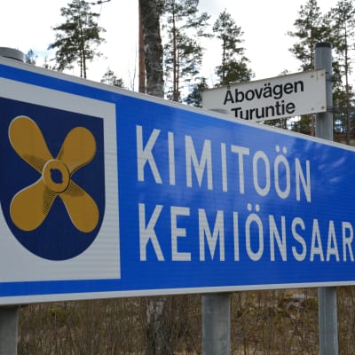 Vägskylt med texten Kimitoön Kemiönsaari samt Kimitoöns kommunvapen.