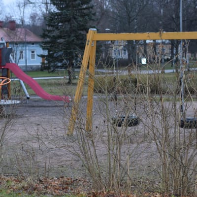 En lekpark tom på barn en höstlik, mulen och snöfri vinterdag i januari.