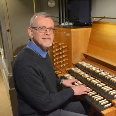 En man spelar på en stor kyrkorgel.
