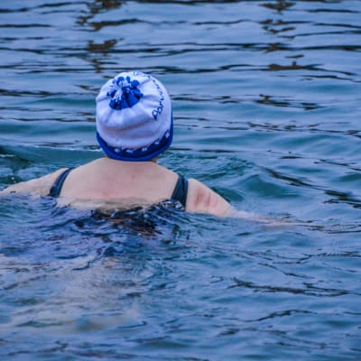 Kvinna med mössa på huvudet simmar