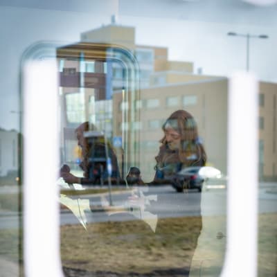 Parturi-kampaaja Saila Suonperä leikkaa asiakkaan hiuksia.
