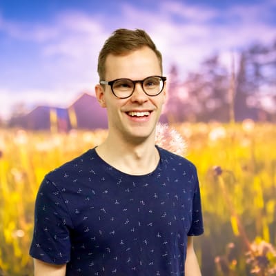 Alaric Mård ler stor rakt in i kameran från en sommaräng.