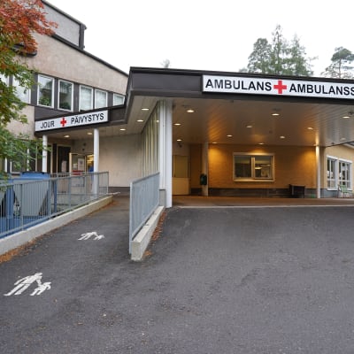 Ingången till jouren vid Raseborgs sjukhus i Ekenäs. Det finns skyltar där det står jour , päivistys och ambulans, ambulanssi, plus det röda korset.
