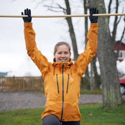 Hanna Kanerva visar pausgymnastik med ett kvastskaft.
