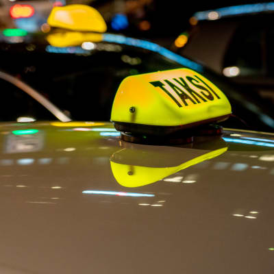 Keltainen taksikyltti taksin katolla.