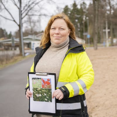 Raseborgs ansvariga parkchef Maria Eriksson poserar vid en väg med en bild i handen. 