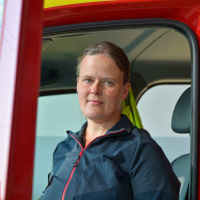 Johanna Nyholm vid en dörren till en brandbil. 