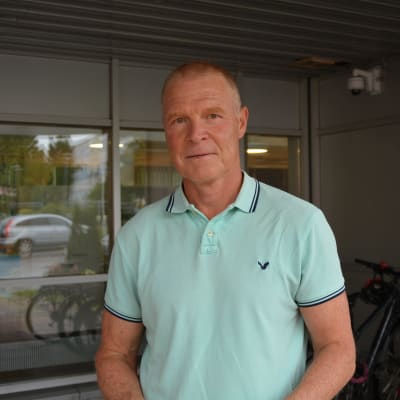 Man i pikétröja ser mot kameran. 